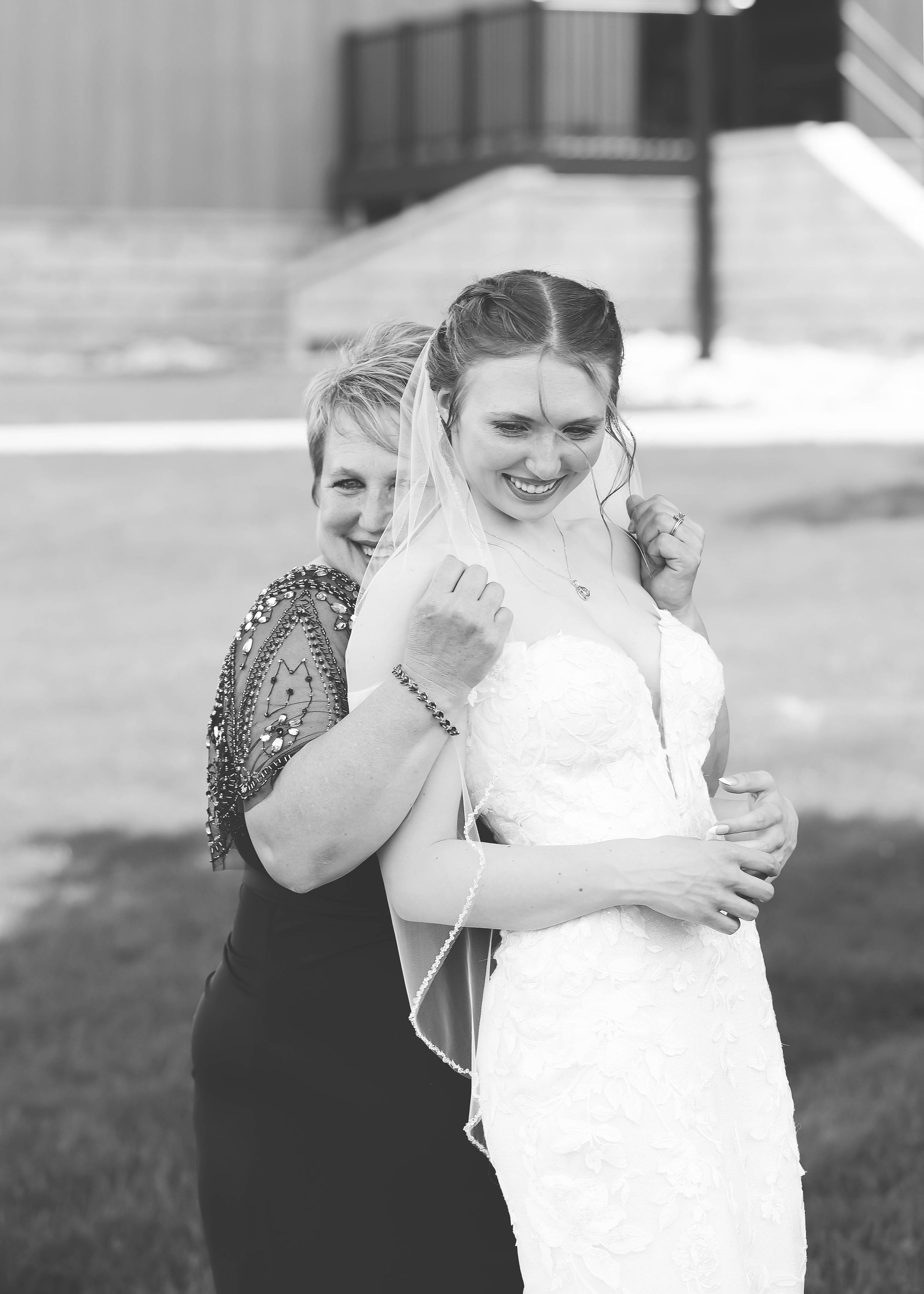 A tender black and white moment shared between a bride in white and her mother.