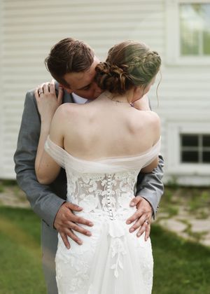Back view of wedding dress showing intricate lace detailing and corset-style closure.