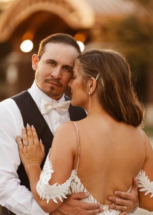 Intimate sunset portrait of newlyweds embracing during wedding reception.