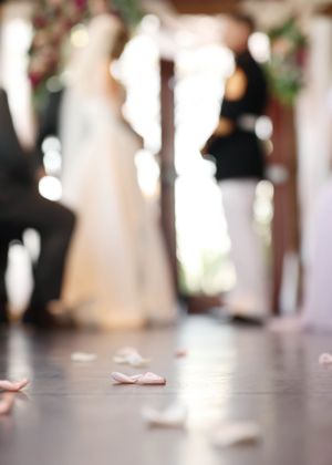 Wedding ceremony participants stand in formation with feet visible on polished floor.
