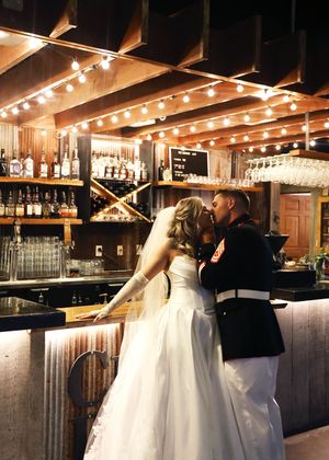 Wedding couple dancing in an elegant bar setting with ambient lighting.