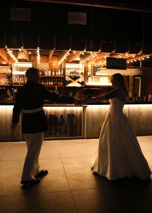 Silhouetted couple dancing in a dimly lit reception venue.