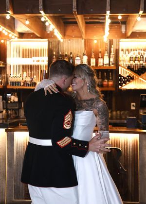 Intimate dance moment captured in a warmly lit rustic bar setting.