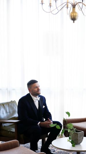 Wedding party members in navy suits relaxing in an elegant lounge setting.