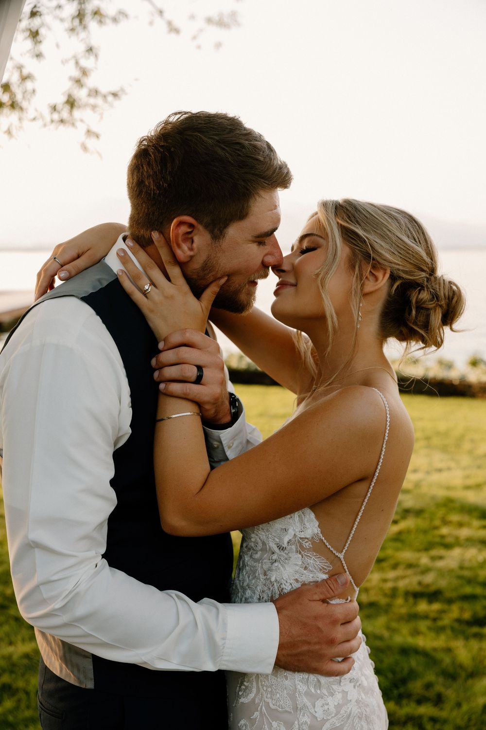 A romantic sunset kiss sequence between a bride and groom in a lush field during golden hour.