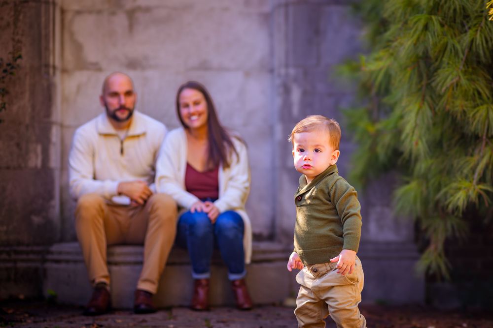 Little boy running toward the camera during a playful outdoor photoshoot.