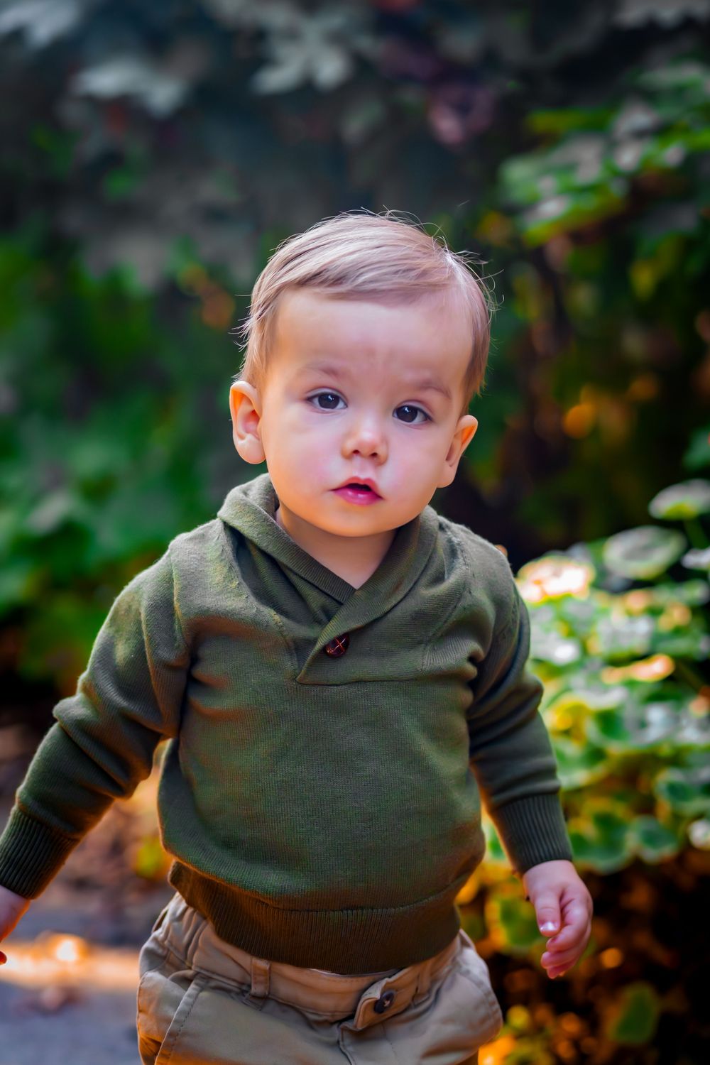 Little boy running toward the camera during a playful outdoor photoshoot