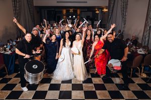 Wedding reception guests dance and celebrate on a black and white checkered dance floor at a lively party.