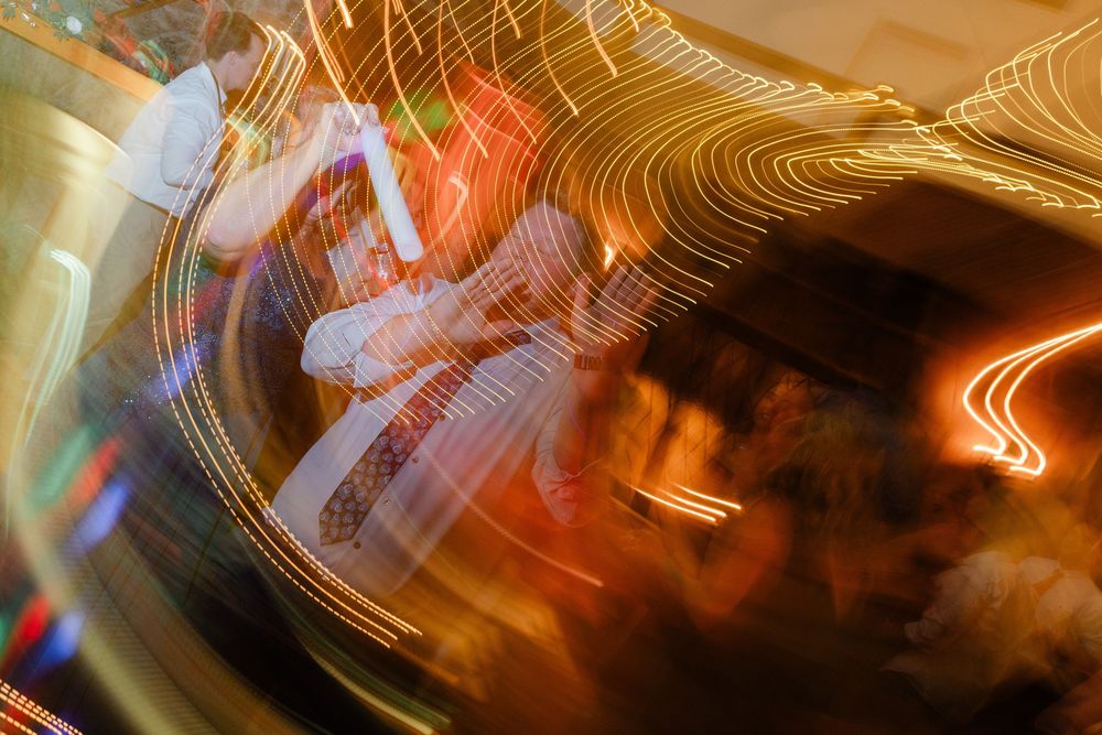 Abstract light painting with swirling golden streaks creating luminous patterns against a dark background.