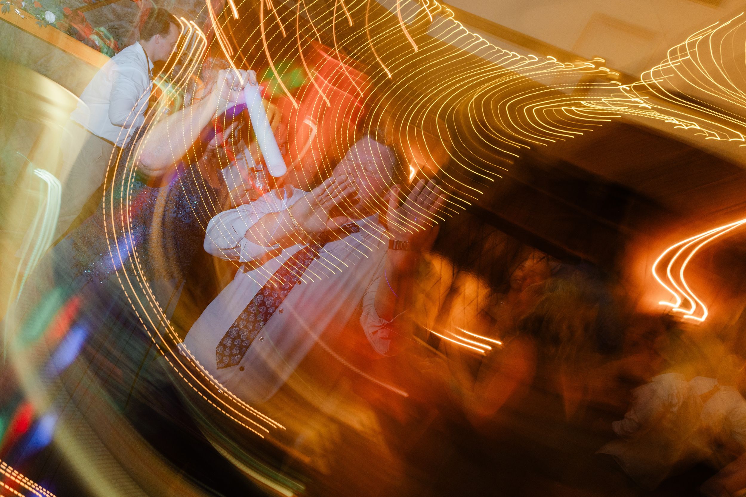 Abstract light painting with swirling golden streaks creating luminous patterns against a dark background.