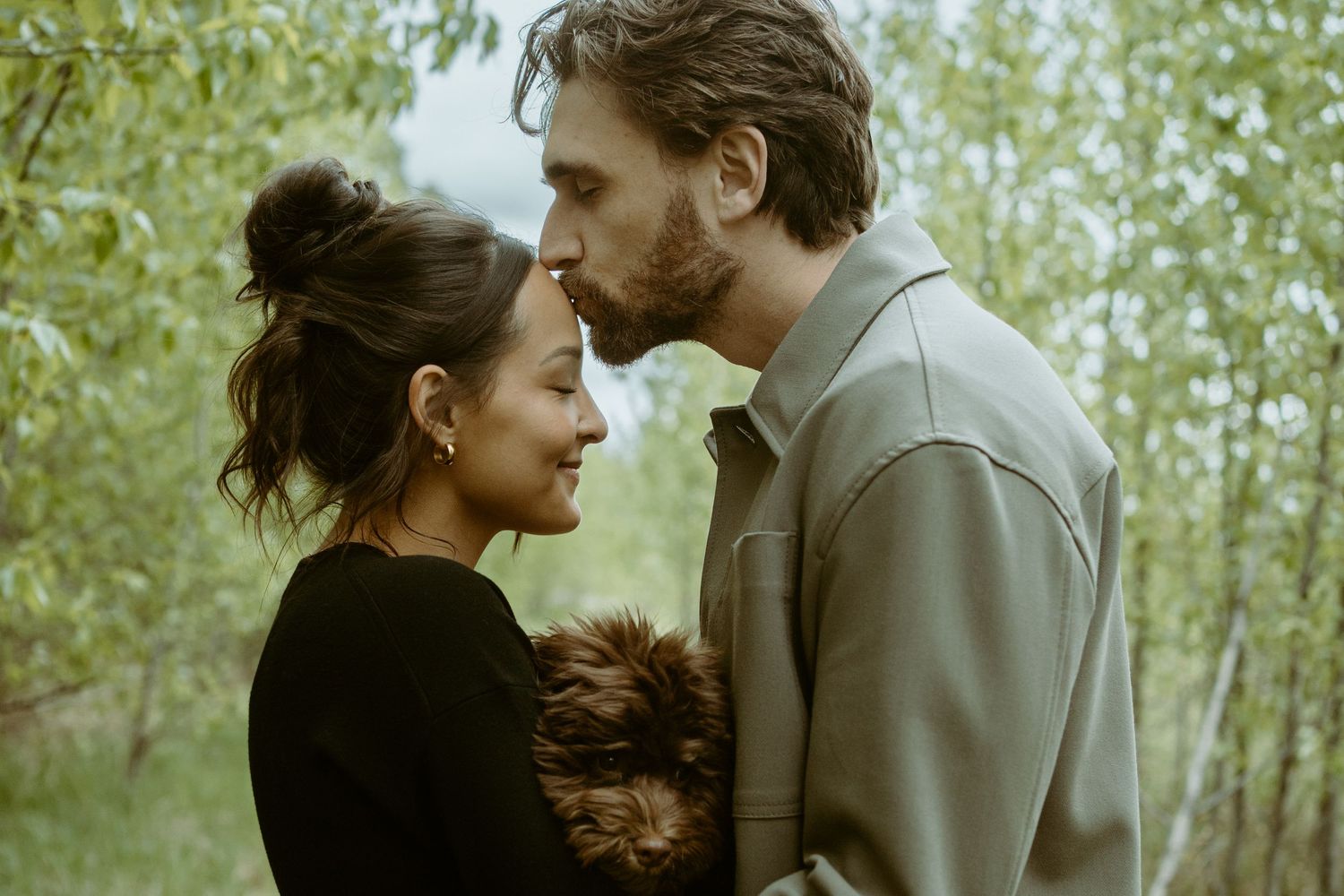 An intimate moment captured in a lush green forest setting.
