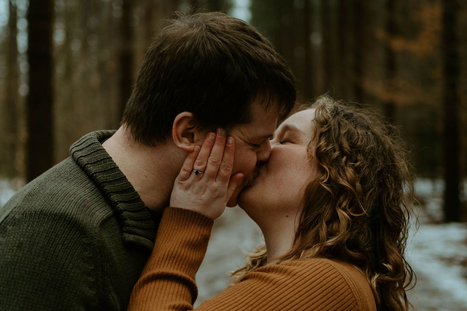 A tender romantic moment captured between a couple in warm sweaters on a winter day.