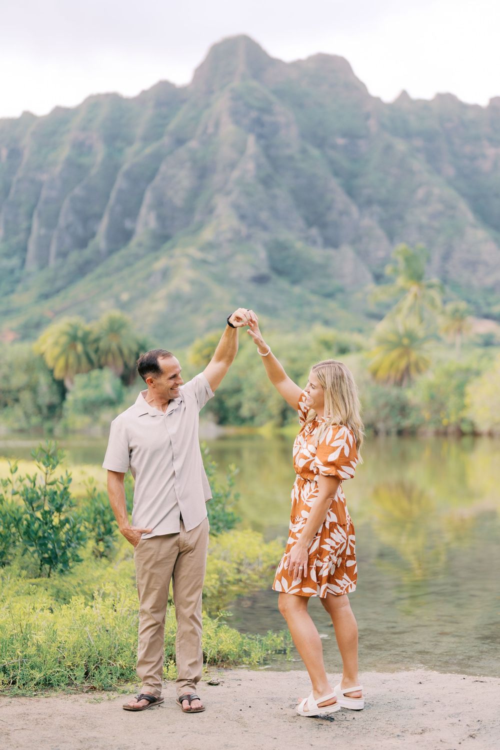Couple dancing together on a path with dramatic Ko'olau Mountains and tropical scenery in the background at Ho'omaluhia Oahu.