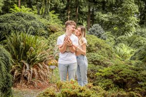 A tender embrace amongst tropical foliage in a lush garden setting.