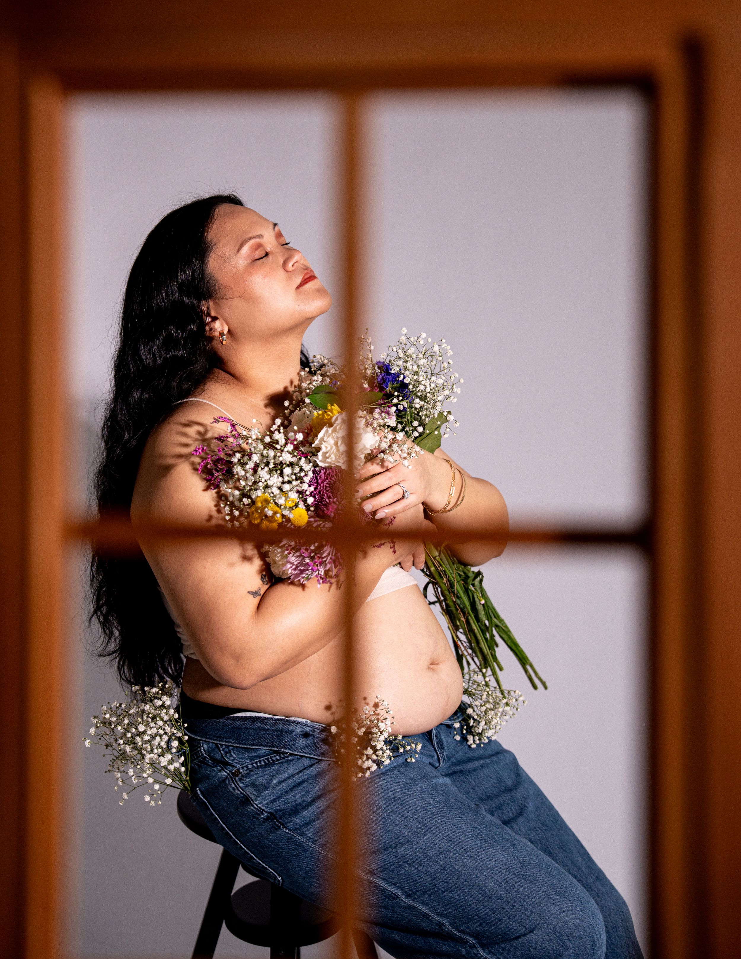 A person in denim poses with flowers against a white background divided by vertical lines creating a triptych effect.