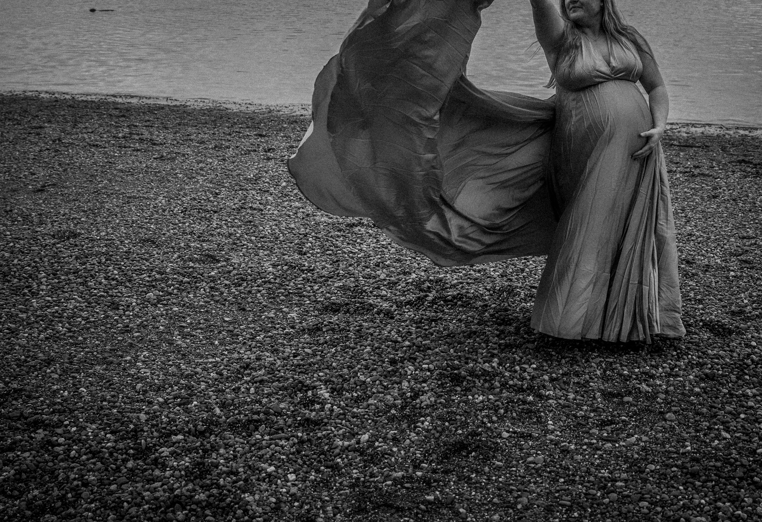 A series of black and white photographs showing people in vintage clothing walking along a rocky beach landscape.