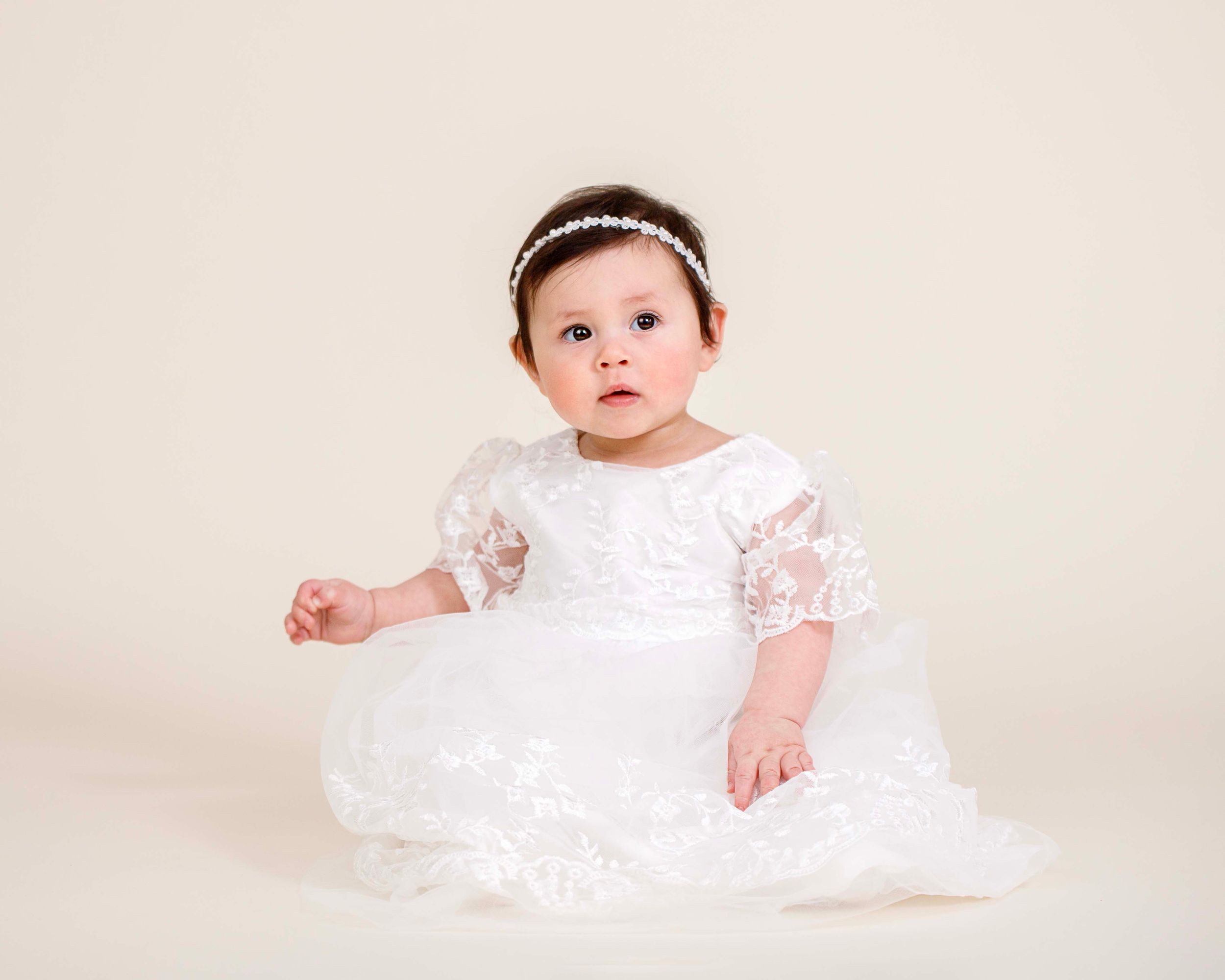 Baby with white Christening gown and neutral background in Ramsey, NJ