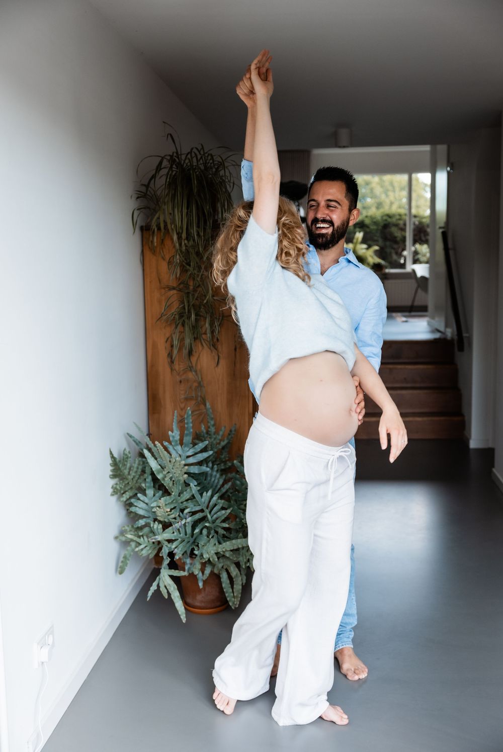 Spontaan portret van zwanger stel tijdens een fotoshoot aan huis