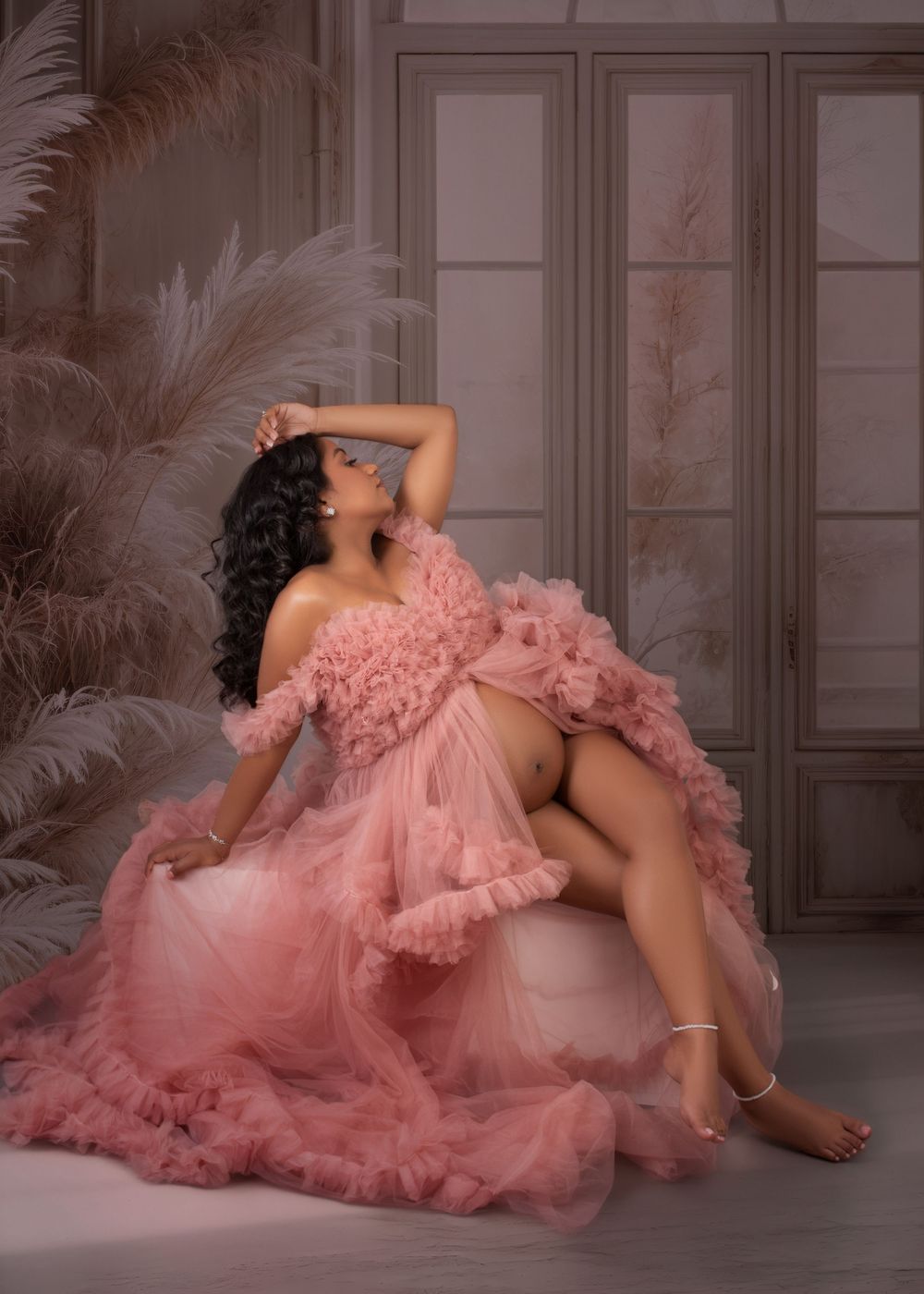 Glamour portrait session with flowing pink tulle gown in an elegant studio setting.