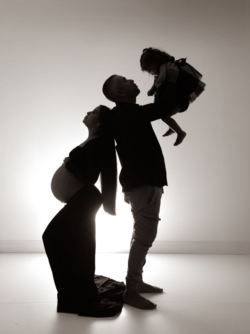 Series of artistic silhouettes showing a mother and small child in tender poses against a white background.