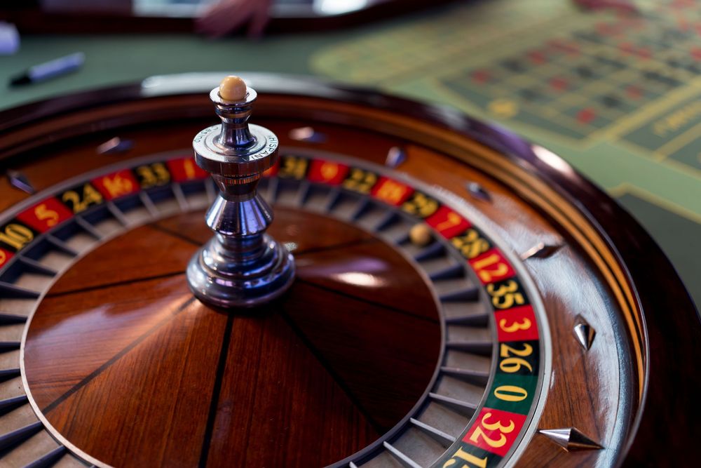 Close-up view of a spinning roulette wheel with red and black numbered slots in a casino setting.