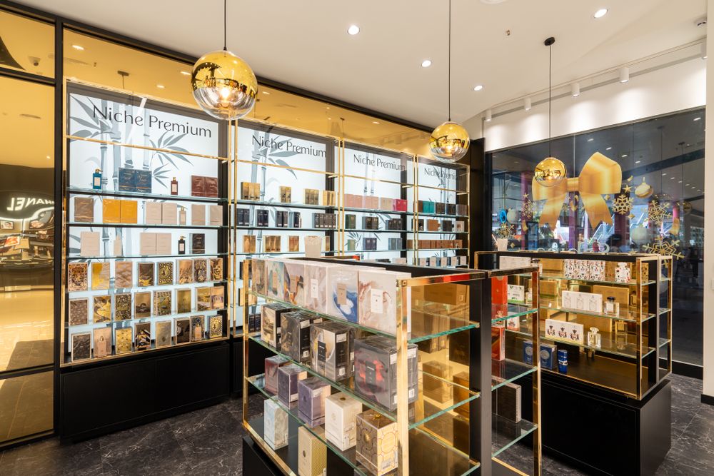 Luxury retail store interior with glass display cases and gold pendant lighting.