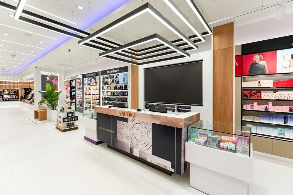 Luxurious retail display area with modern lighting and large wall-mounted screen in upscale store setting.