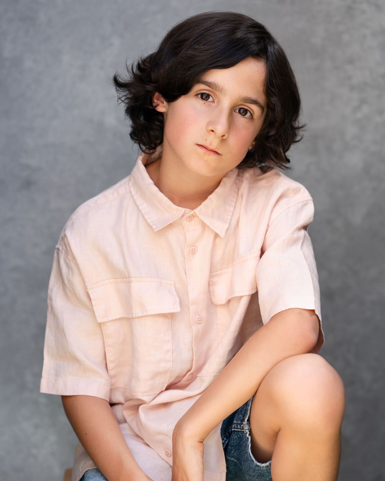 Studio portrait against white background wearing blue floral print and white top.