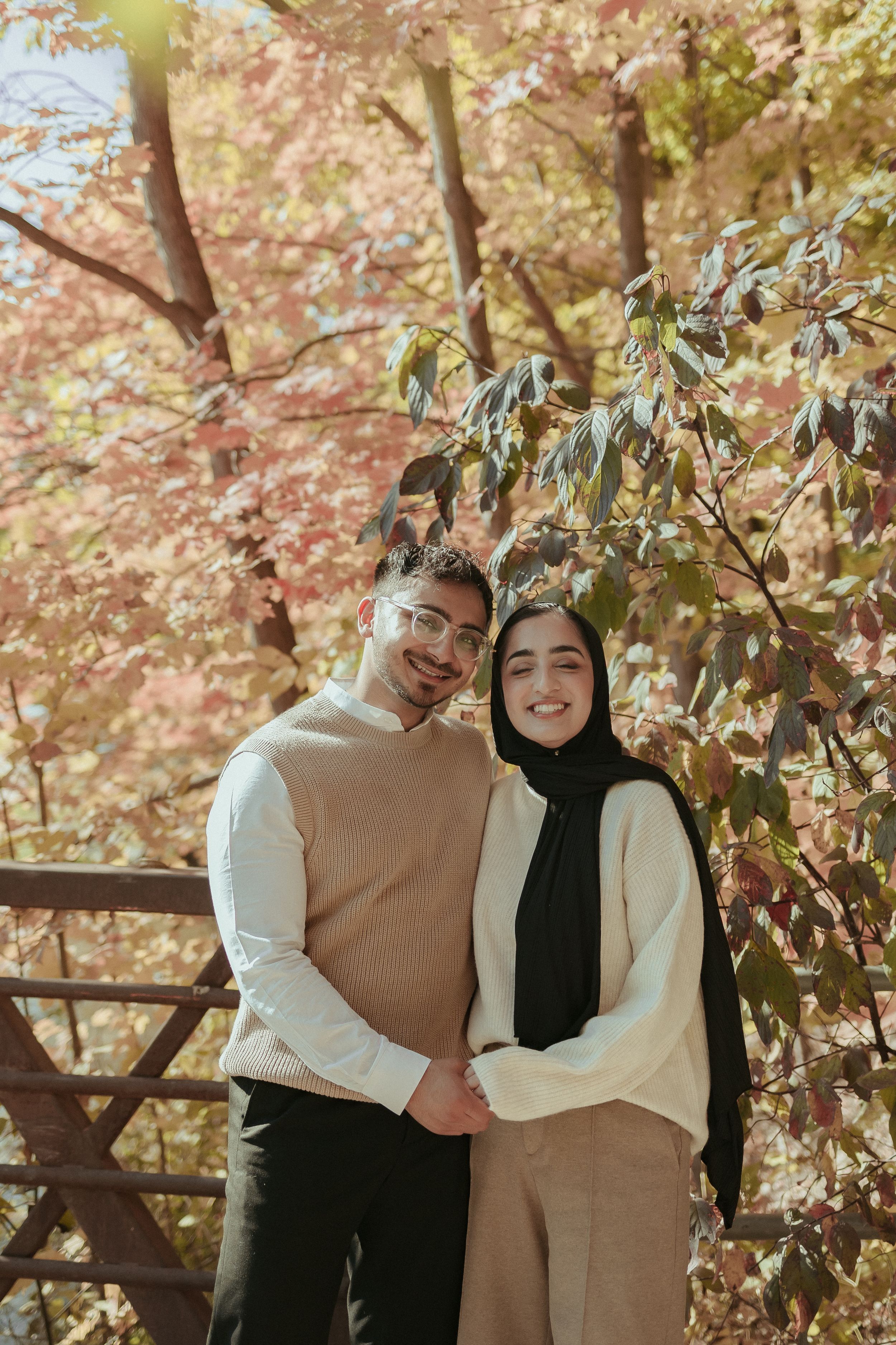 Couple in coordinated neutral outfits posing together during fall season.