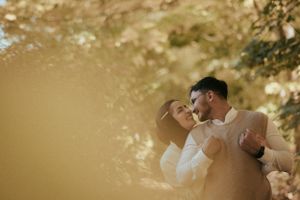 A romantic autumn photoshoot with warm golden sunlight filtering through trees.