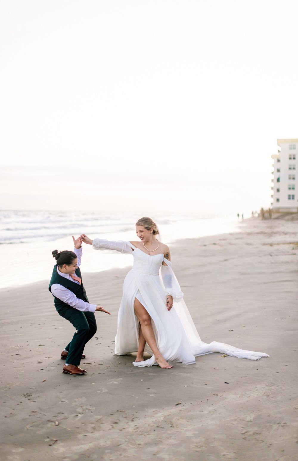 Playful beach wedding photos showing two people posing on sandy shores.