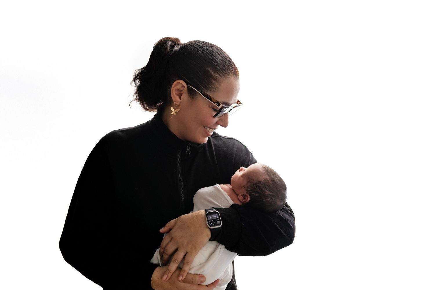 Tender black and white photo of newborn getting examined against blurred background.