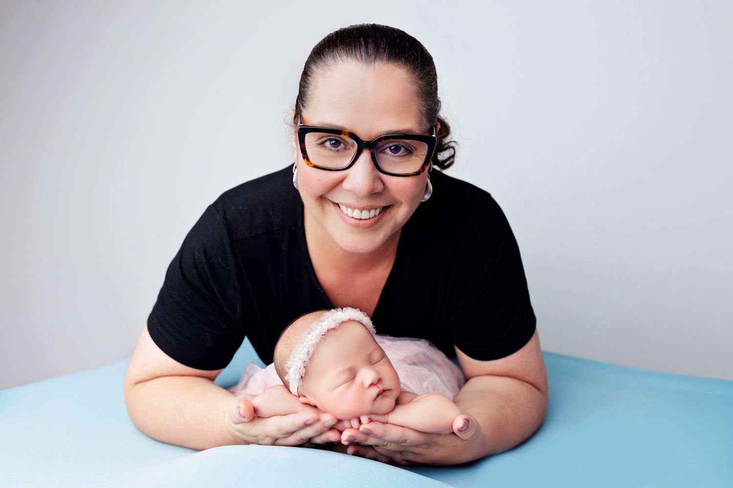 Tender black and white photo of newborn getting examined against blurred background.