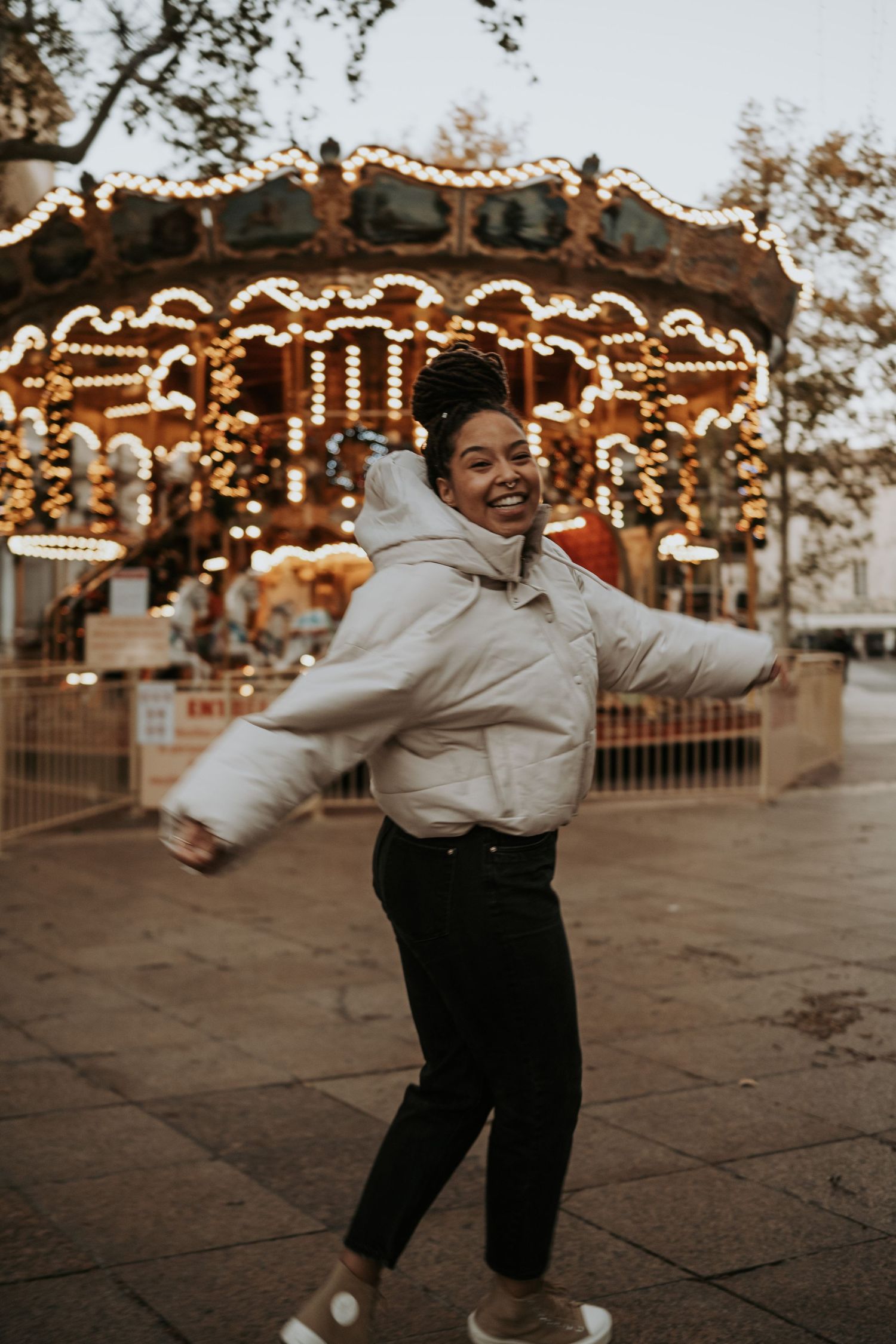 Joyful candid moment at carnival with illuminated carousel in background.
