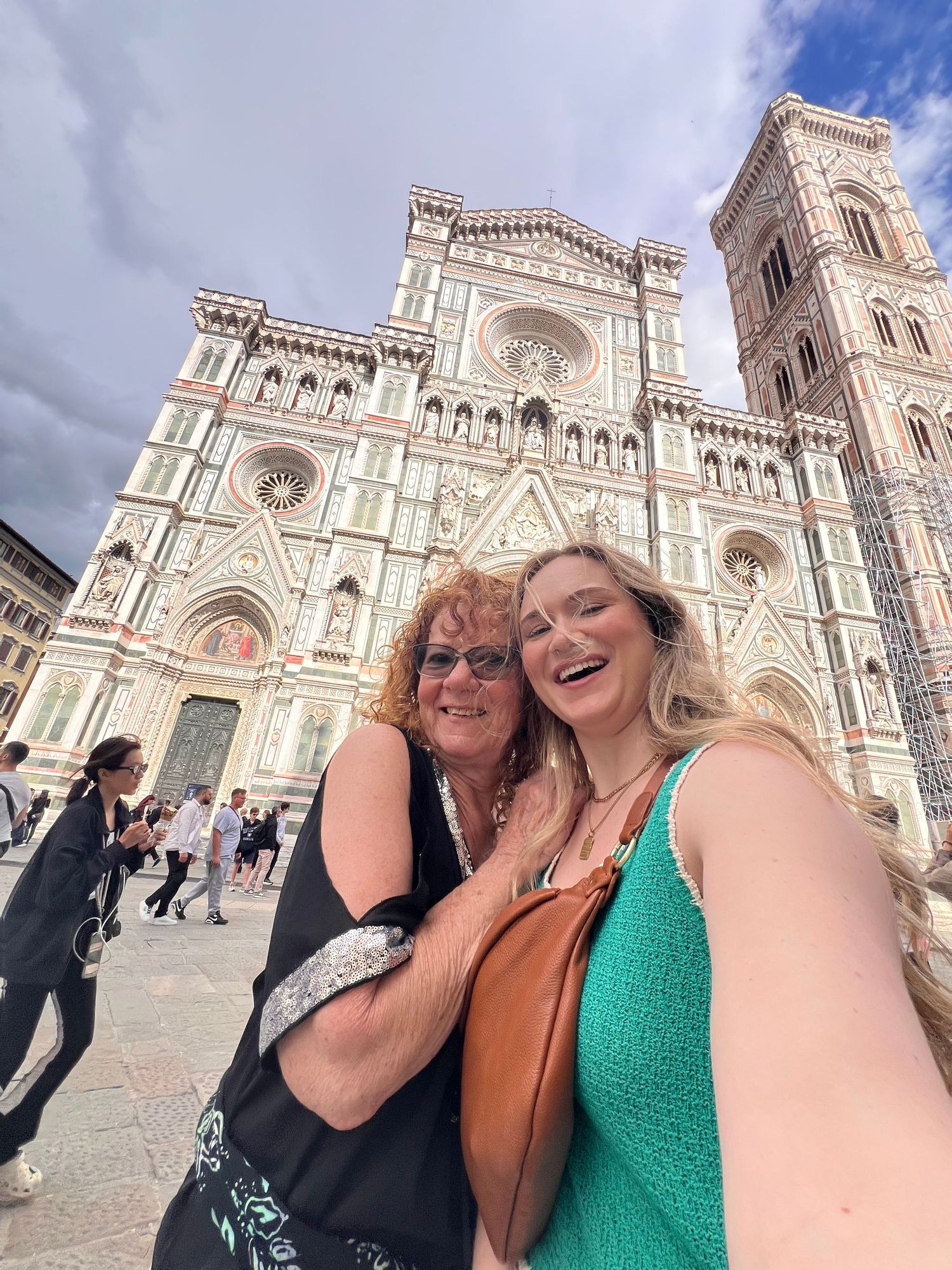 Two women smiling for a selfie in front of the Florence Cathedral, Duomo di Firenze, Italy.