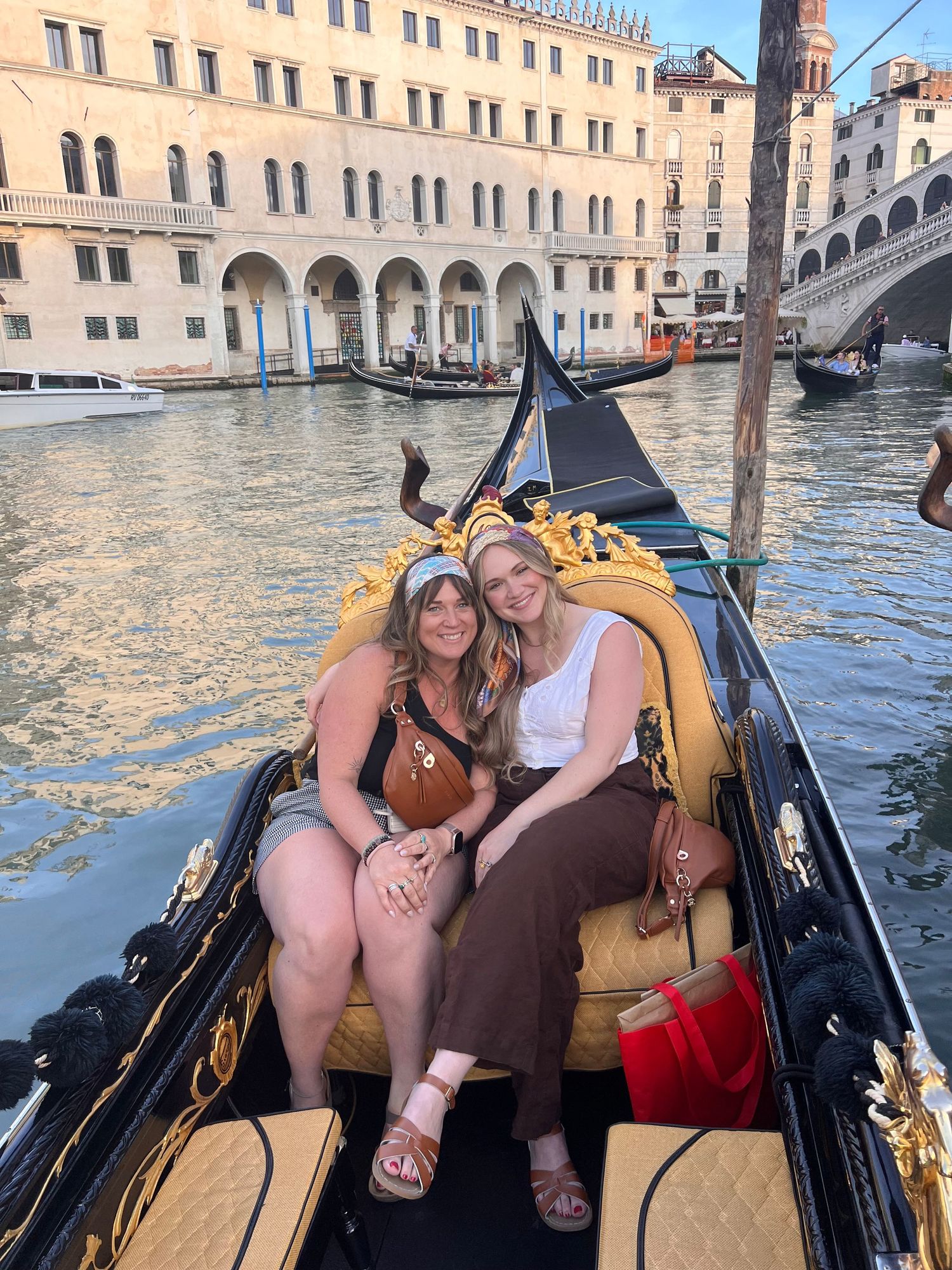 Two women enjoy a gondola ride on the Grand Canal in Venice, Italy.