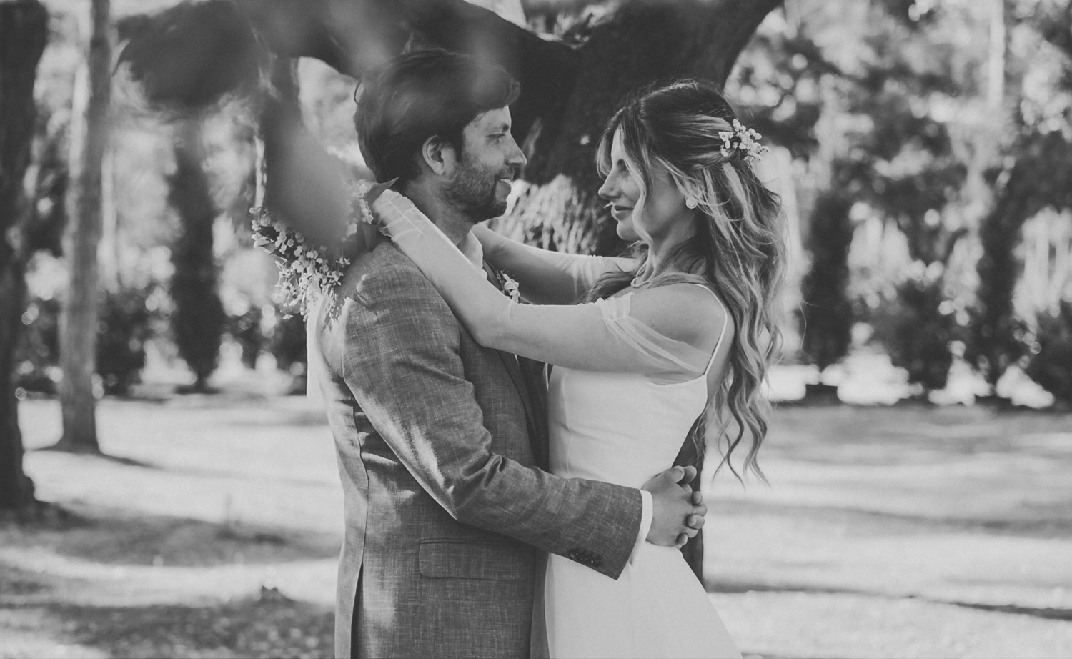 Black and white romantic portrait of a couple celebrating their wedding day in an elegant outdoor setting.
