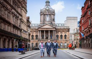 Panoramic cityscape view of historic Liverpool buildings and architecture with pedestrians walking.
