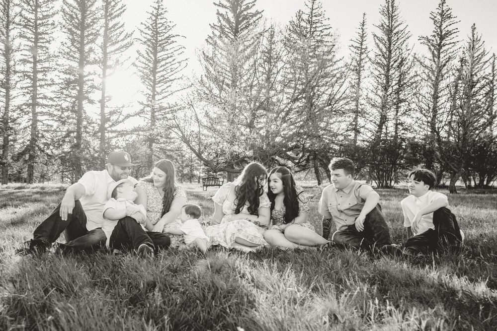 Friends in coordinating pastel outfits share candid laughing moments during photo session.