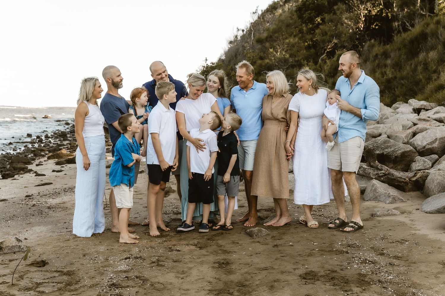 Family with dog walking across paddock during family portrait shoot in Brisbane