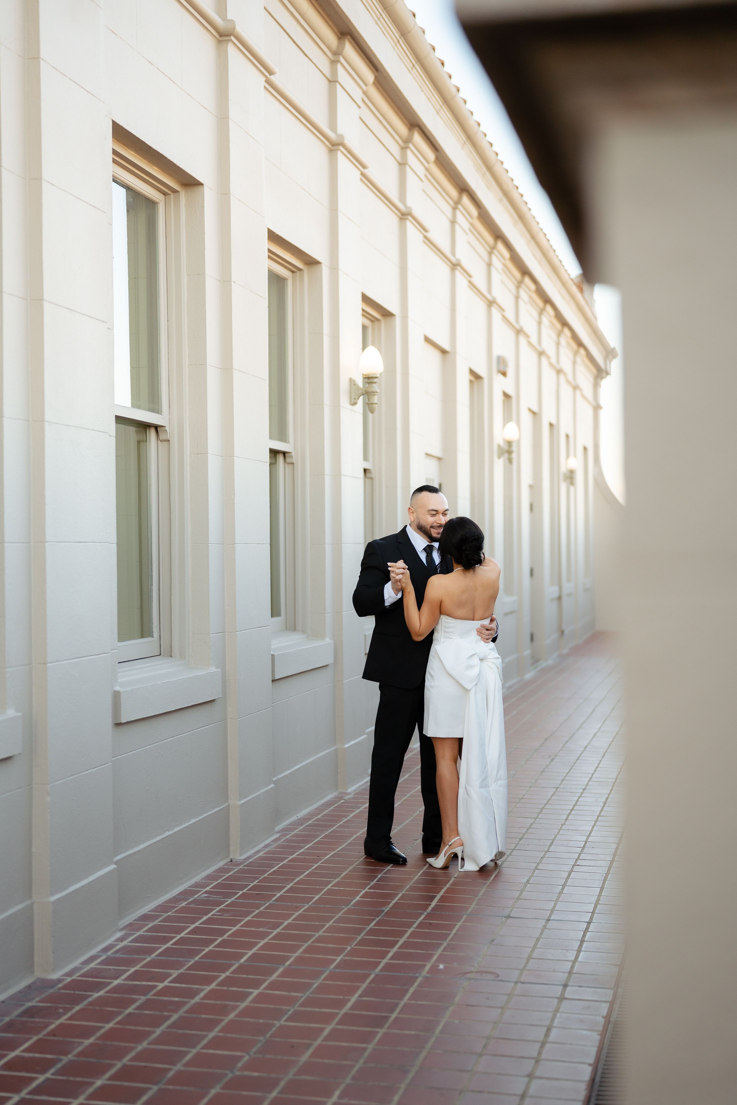 Bride and groom share a romantic moment in a elegant corridor. Fresno California Wedding Photographer and Videographer