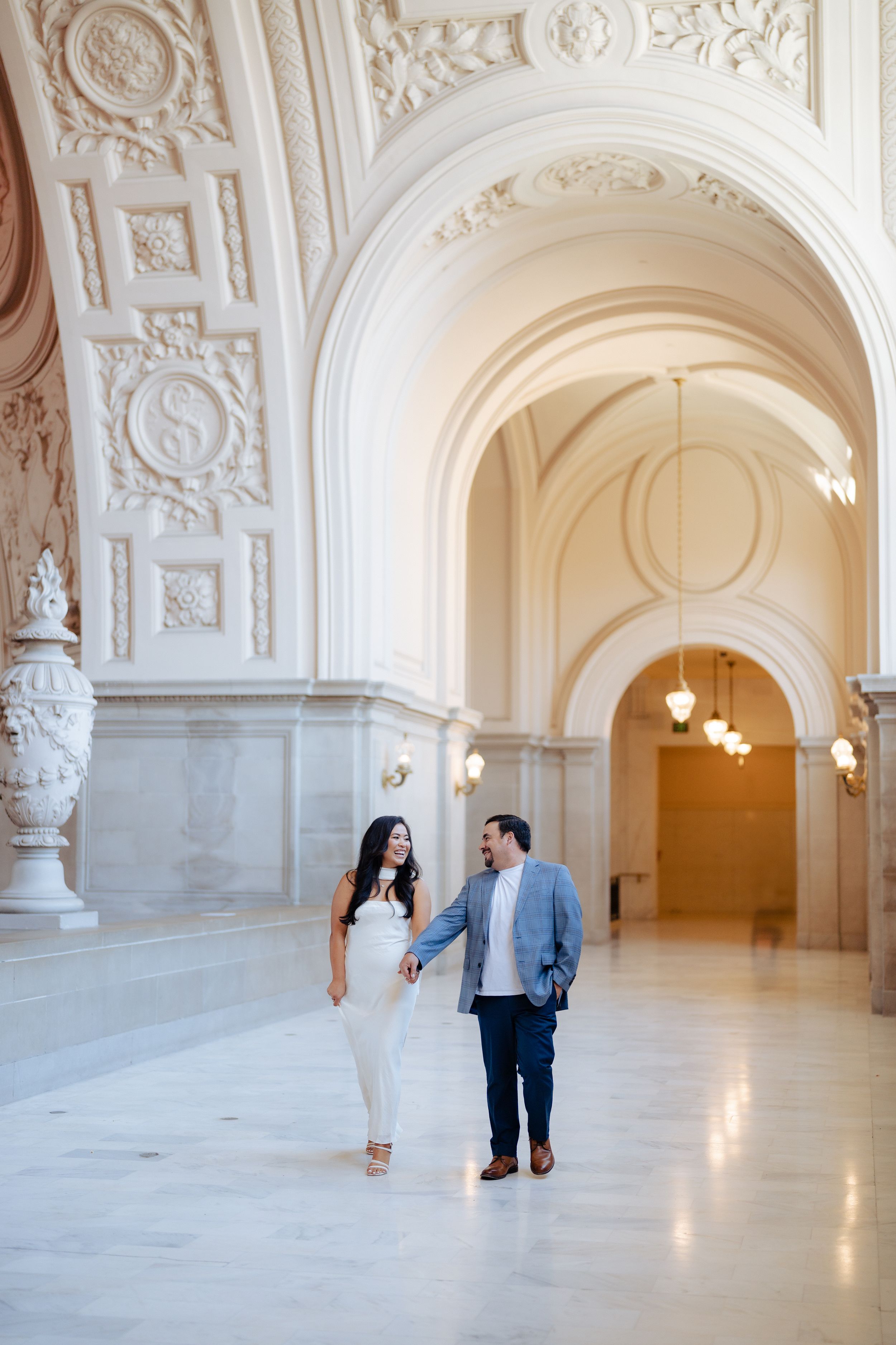 Couple walking hand in hand through a hallway. Fresno California Wedding Photographer and Videographer