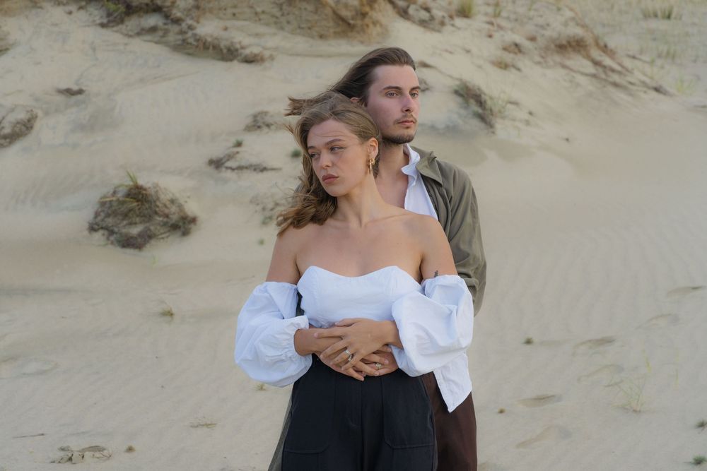 A man is holding a woman at the seaside.