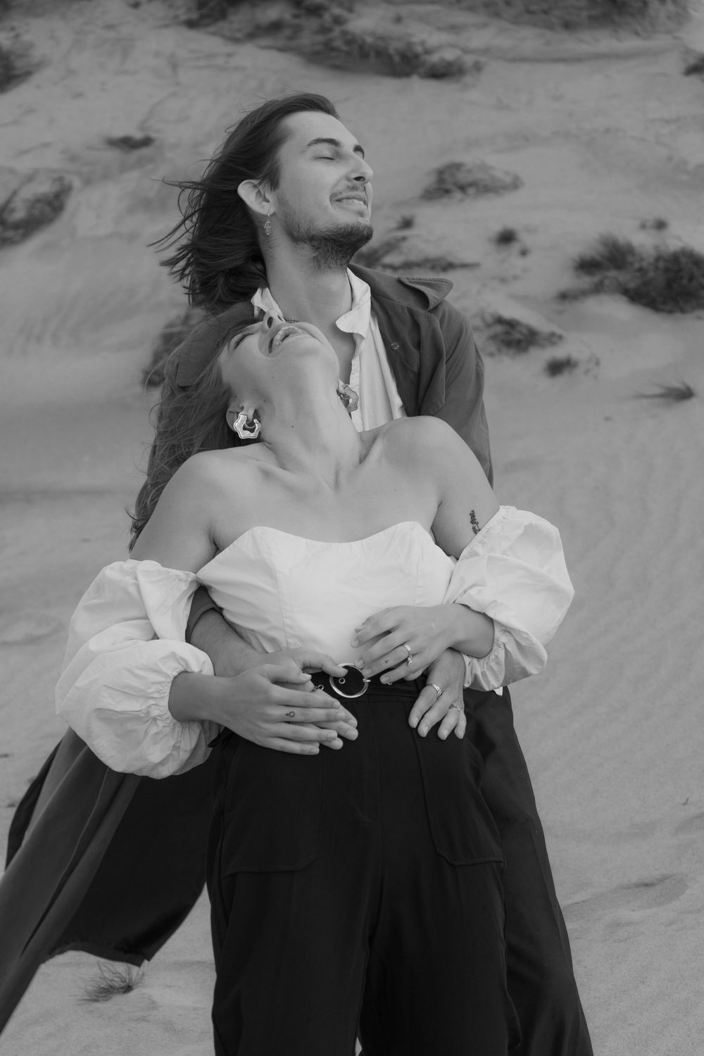A man and a woman laughing at the seaside.