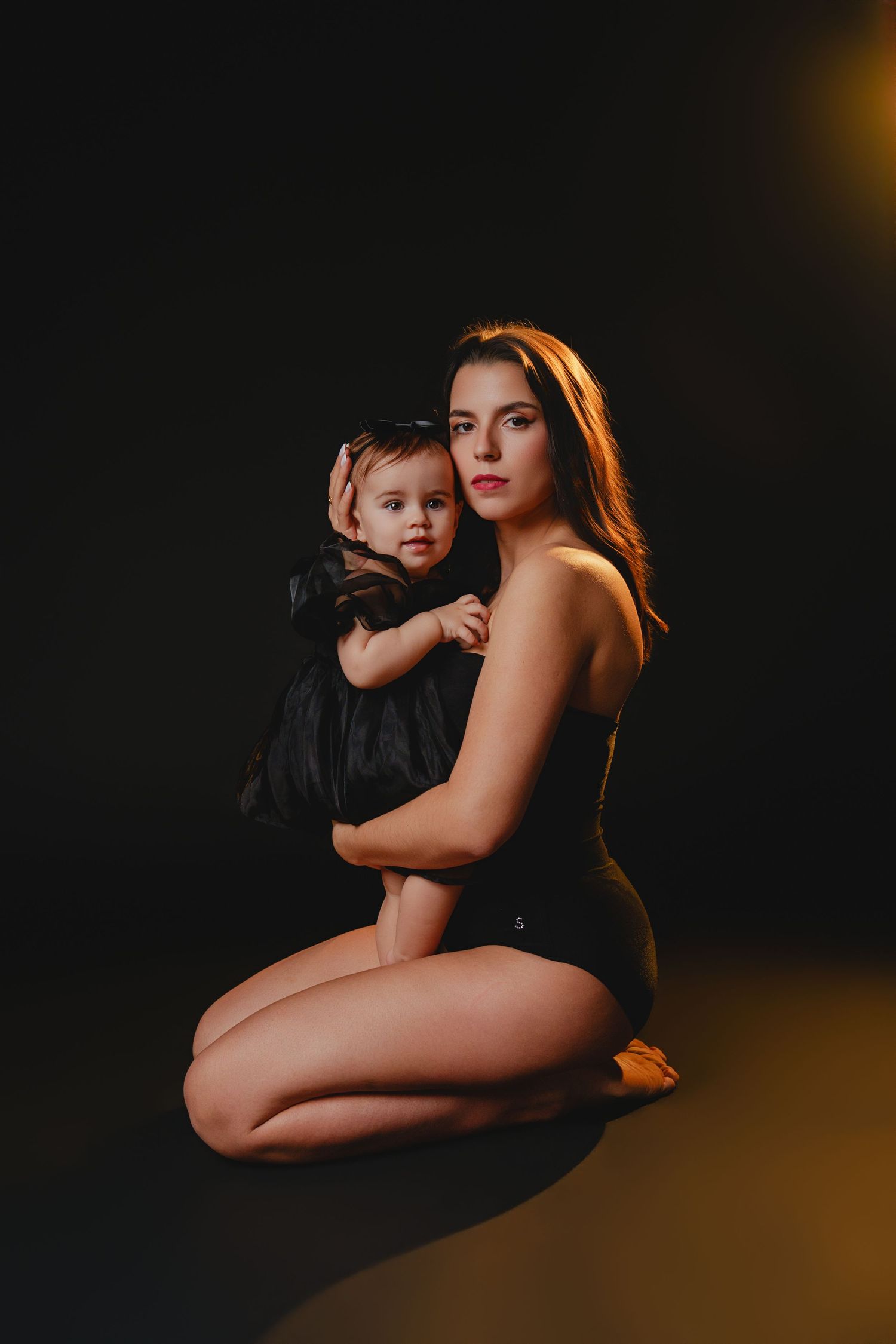 Dramatic dark portrait with warm rim lighting creating intimate mood.