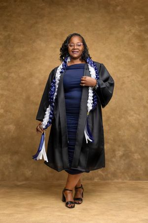 Graduate in black academic regalia and navy dress poses against brown backdrop in series of celebratory photos.