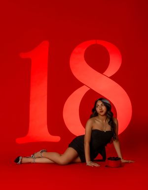 A silhouette of a person posing against a dramatic red background with large illuminated numbers.