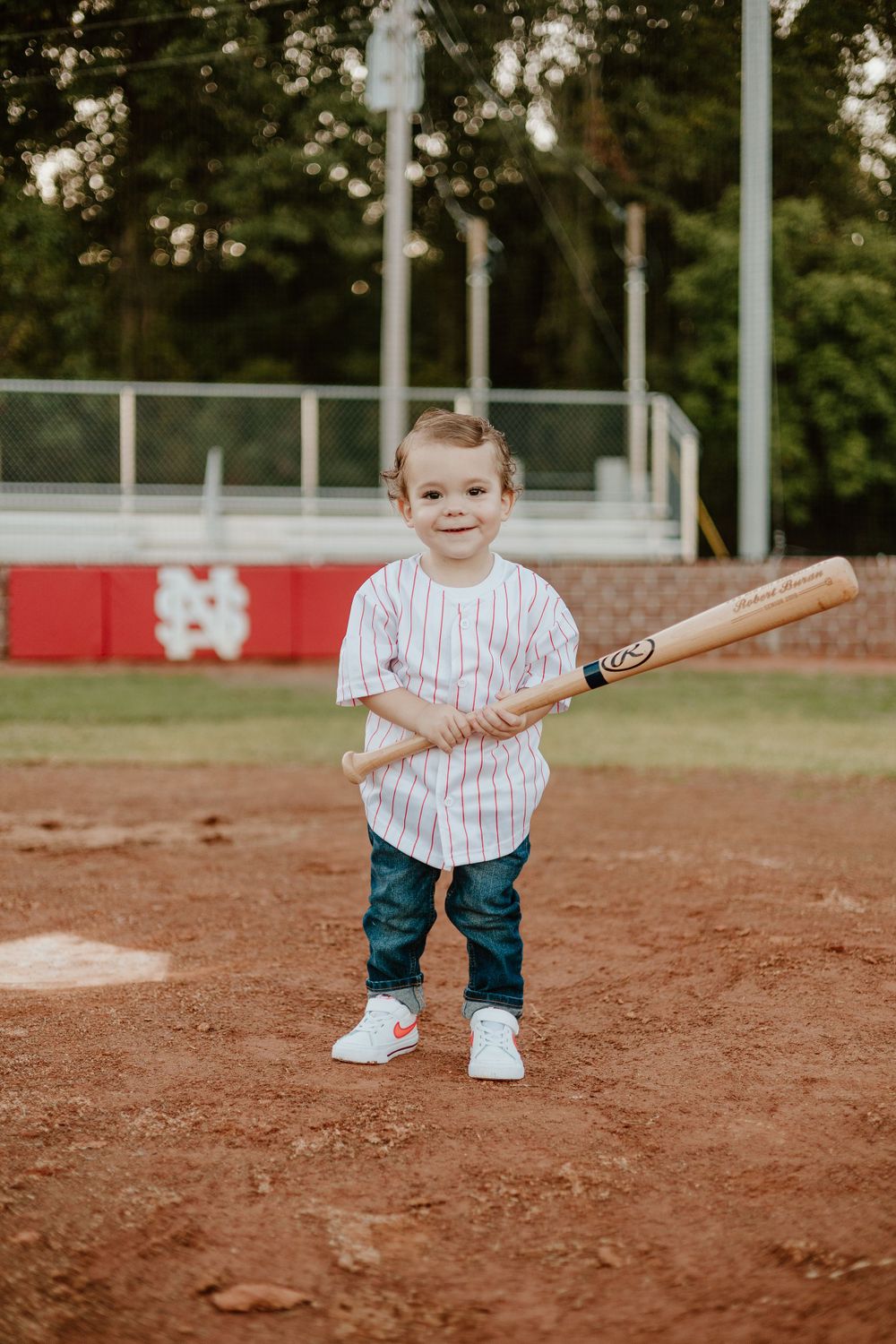 A baseball-themed photo featuring a wooden bat on a dirt infield.