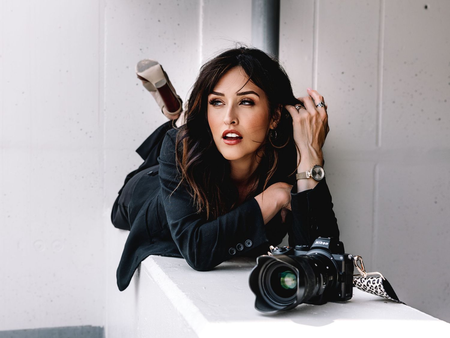 A creative collage of four fashion poses on a white background showcasing black outfit and dark hair.