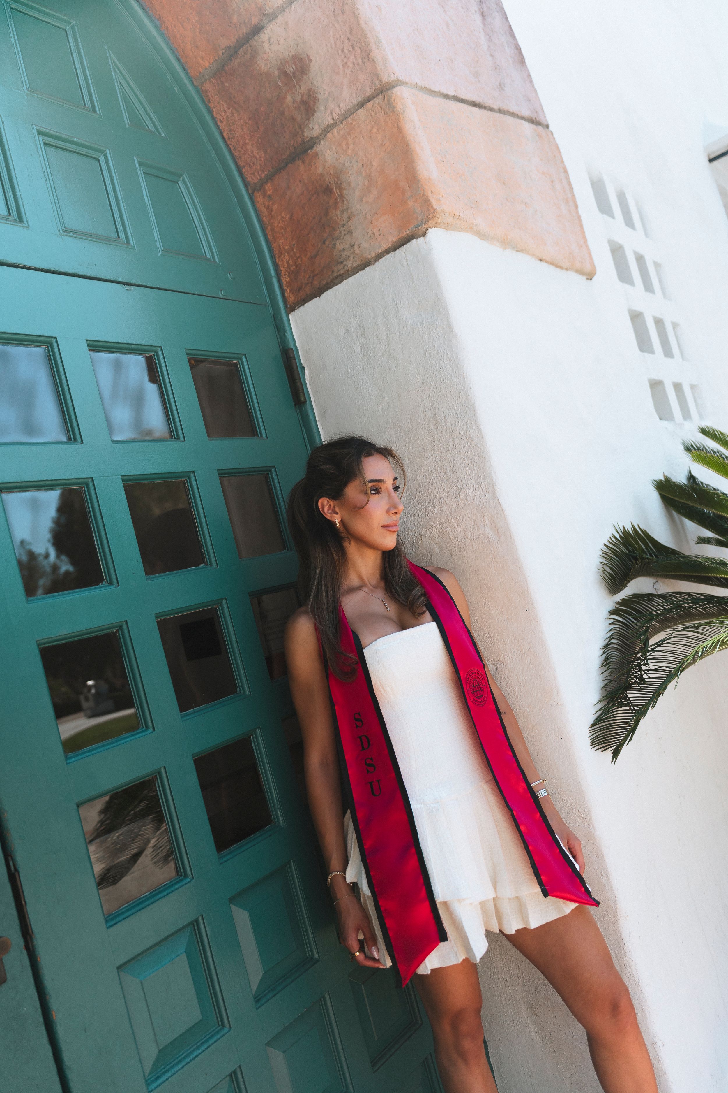 A young woman poses for a picture with a bright red stole around her neck
